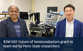 two individuals pose for a photo in front of lab equipment